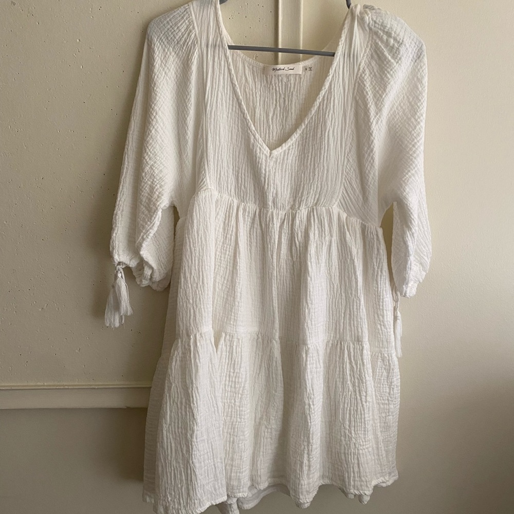 white dress with tassels on sleeves